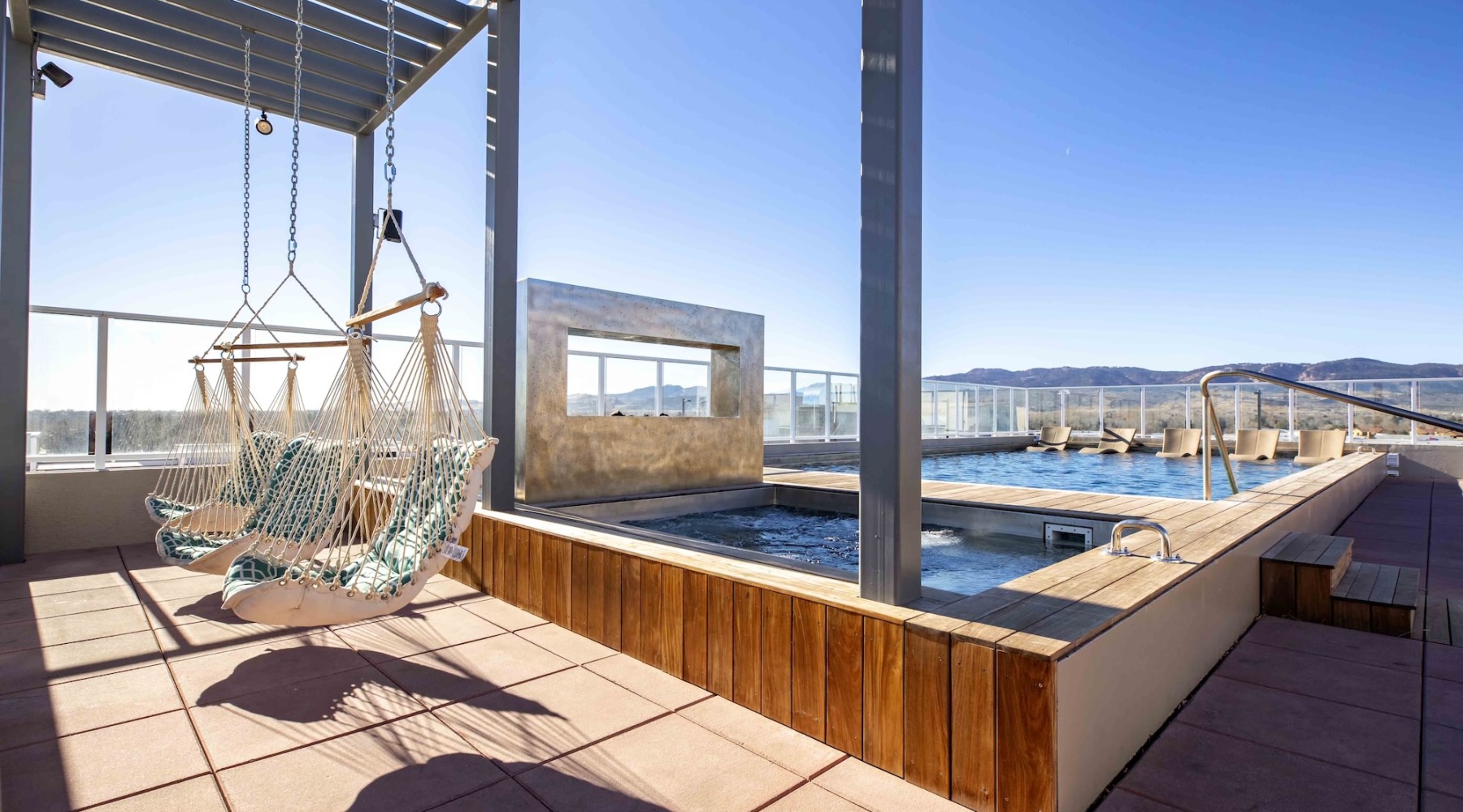 a deck with a pool chairs and a metal structure