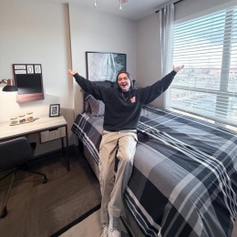 a person sitting on a bed in a bedroom