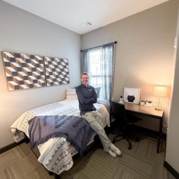 a person leaning on a bed in a bedroom