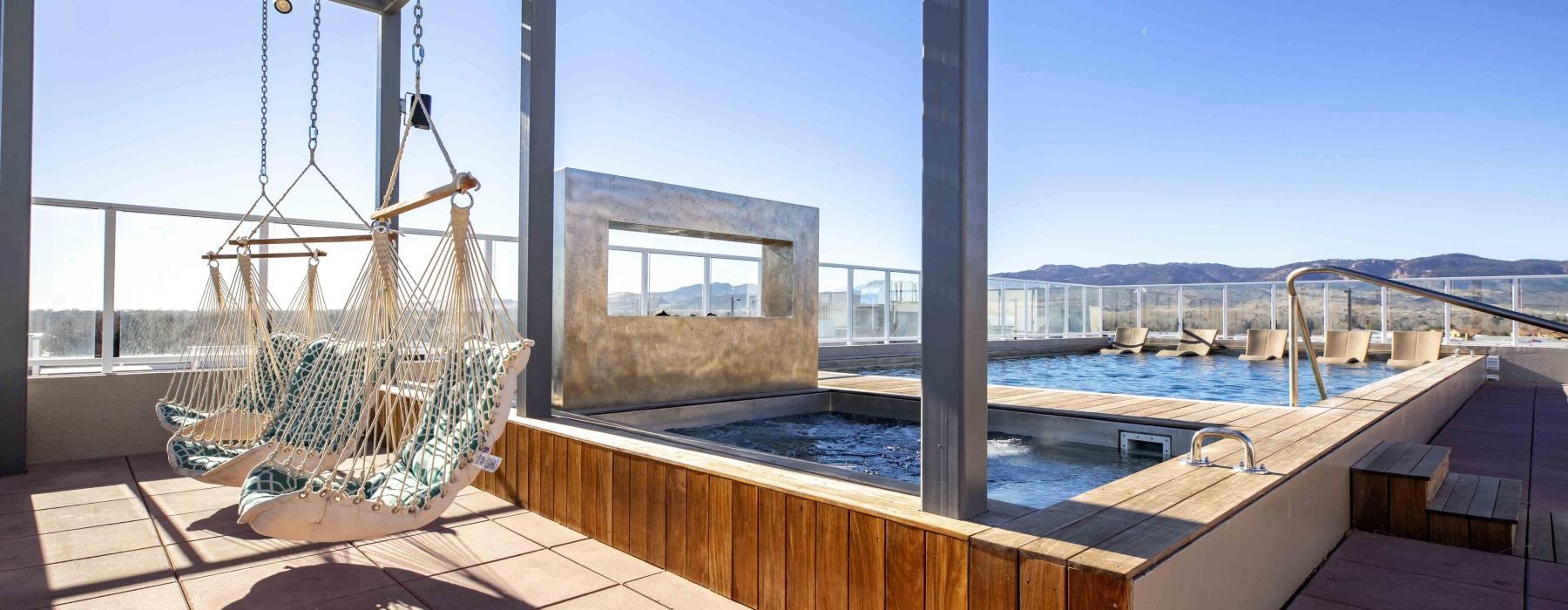 a deck with a pool chairs and a metal structure